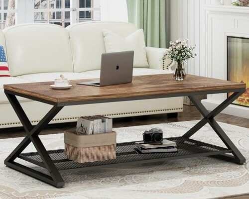Modern living room with a wooden coffee table, laptop, and decor items.